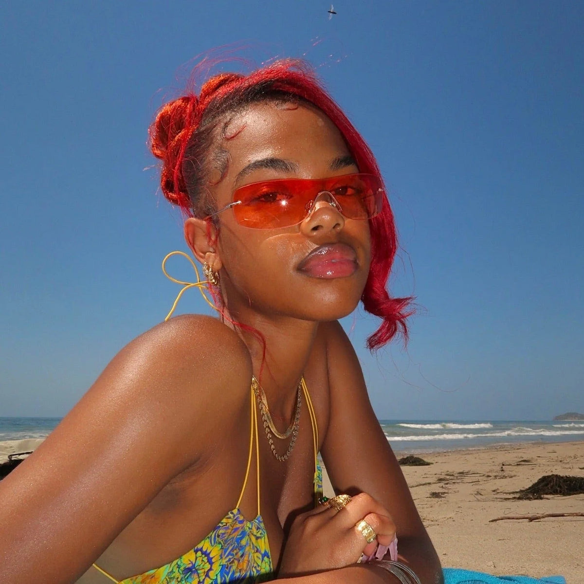 Red-haired girl posing in the sun wearing her retro oversized sunglasses from Giant Vintage