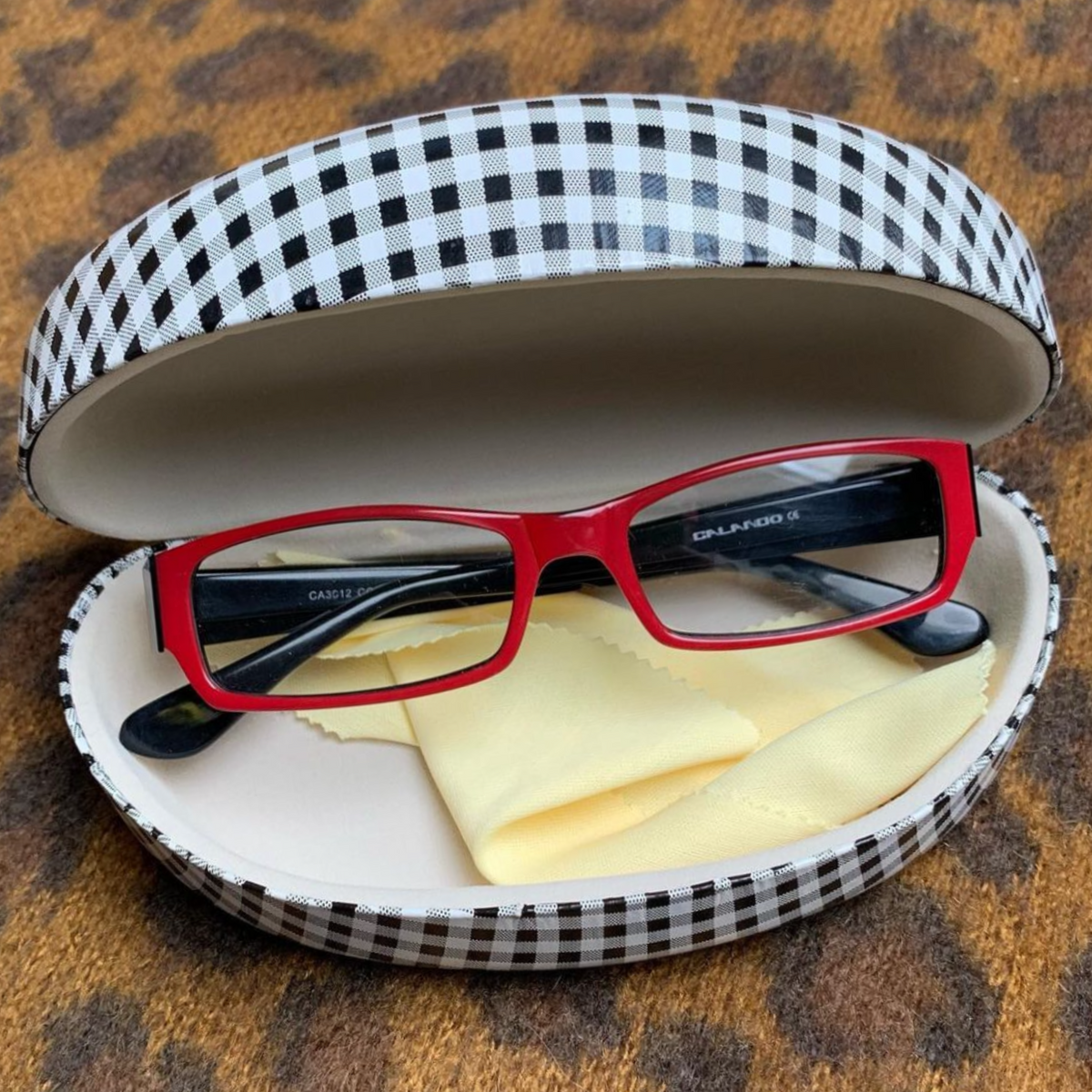 Lifestyle image of the a black and white checkered case in the style PUNK with polished red glasses from Giant Vintage