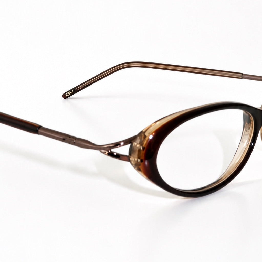 Oval eyeglasses with a tortoiseshell patterned frame and thin metal temples, shown on a plain white background.