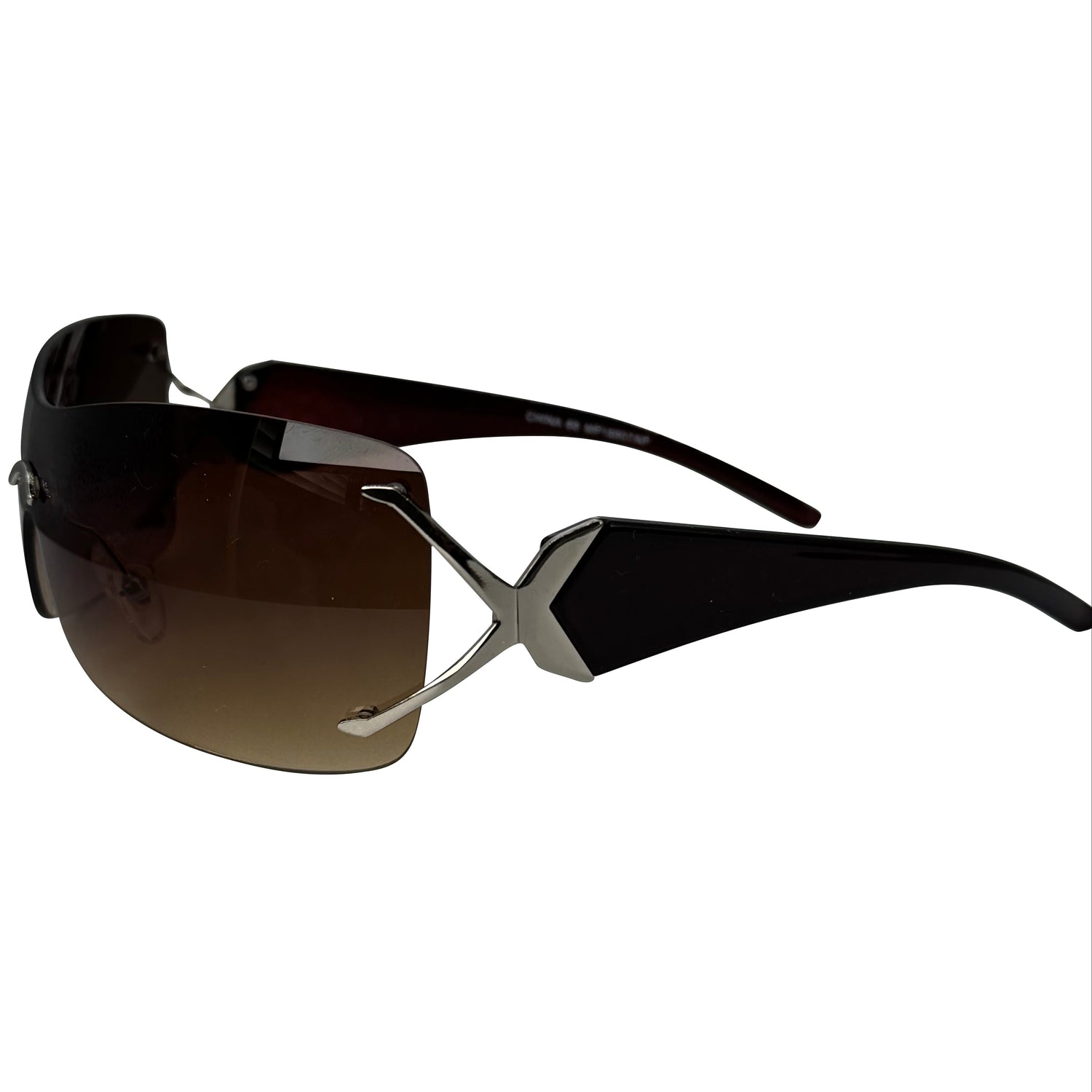 Rimless sunglasses with a wraparound brown gradient lens, black temple arms, and a silver geometric metal accent on the hinge.