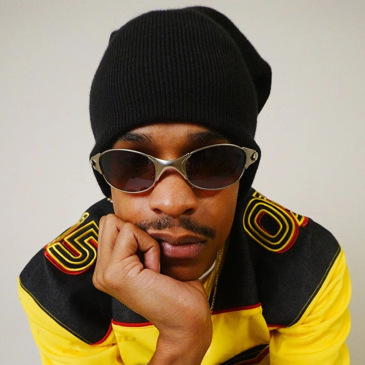 Male posing in a beanie posing in a sleek 90's inspired sunglasses from Giant Vintage
