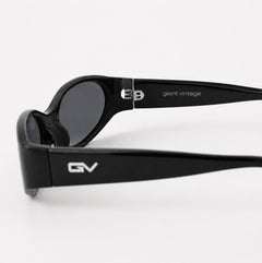 Black sunglasses with dark lenses and silver 'GV' and 'giant vintage' branding on the arms, photographed on a clean white background.