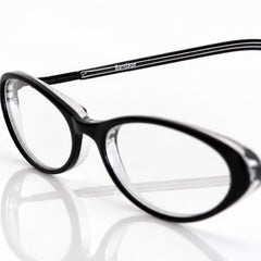 Black BANDAGE eyeglasses with clear lenses and thin silver temples, shown on a reflective white surface against a white background.