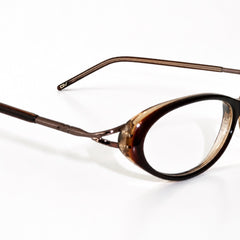 Oval eyeglasses with a tortoiseshell patterned frame and thin metal temples, shown on a plain white background.