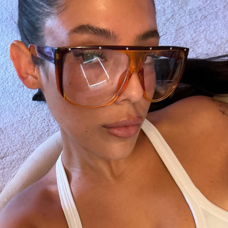 Person wearing large sunglasses with a neutral background