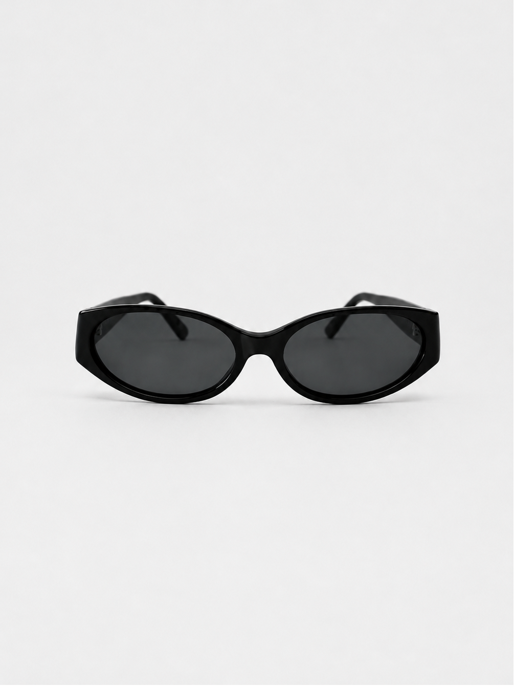 Black cat-eye sunglasses with dark lenses, photographed from the front on a light gray background.