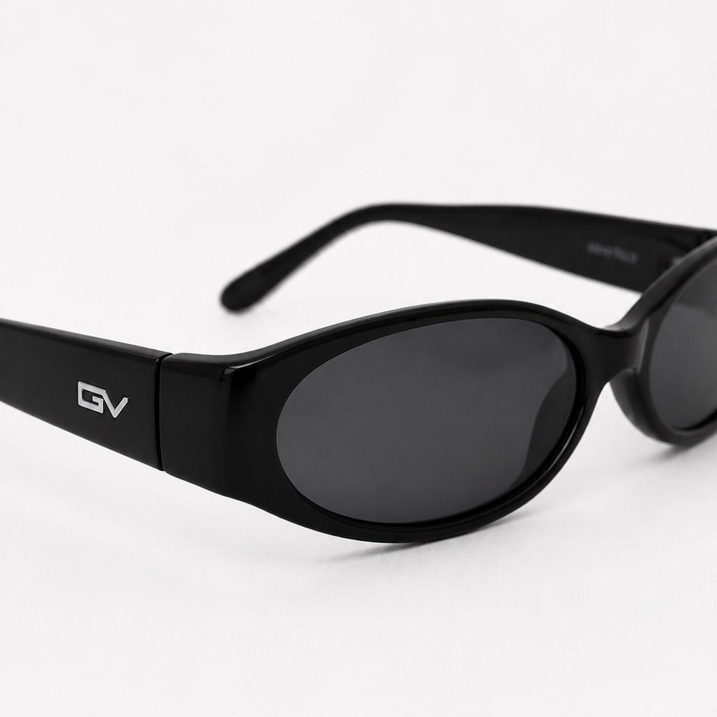 Black oval sunglasses with dark lenses and a visible GV logo on the temple, photographed on a clean white background.