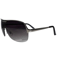 A front-facing product shot of the EXOTIC sunglasses, featuring a rimless shield design with oversized, dark-to-light gradient lenses. The frames are accented by a sleek silver double-bridge bar across the top and silver arms visible through the lenses.
