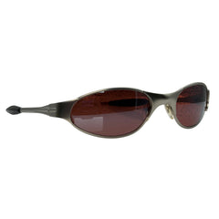 F1 Oval sunglasses with a dark metallic bronze frame and brown tinted lenses, shown from a side angle on a plain white background.