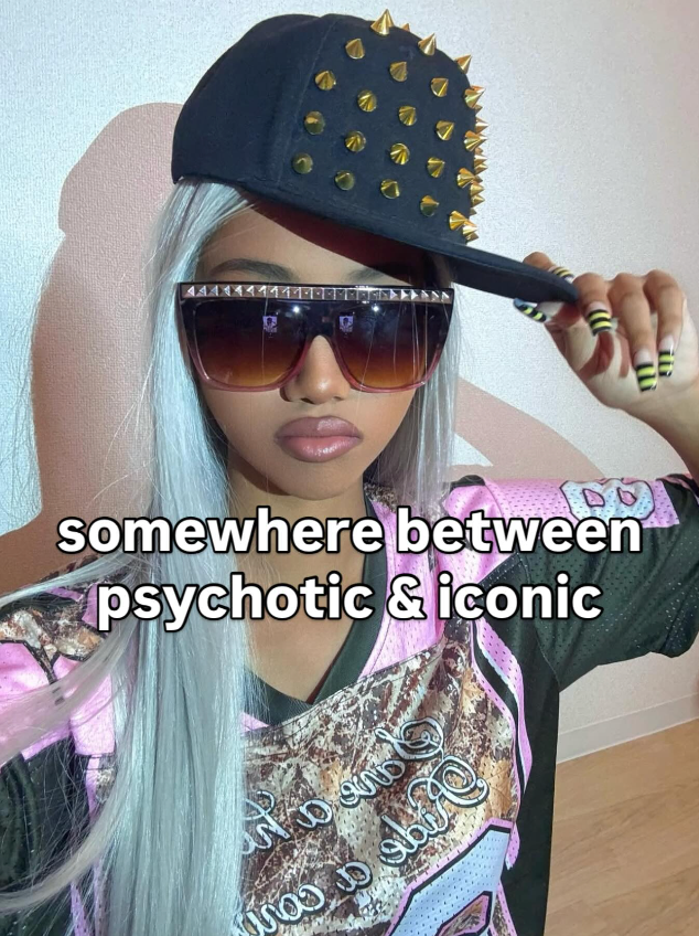 Person wearing a black cap with gold studs and sunglasses, with text 'somewhere between psychotic & iconic' on a neutral background.