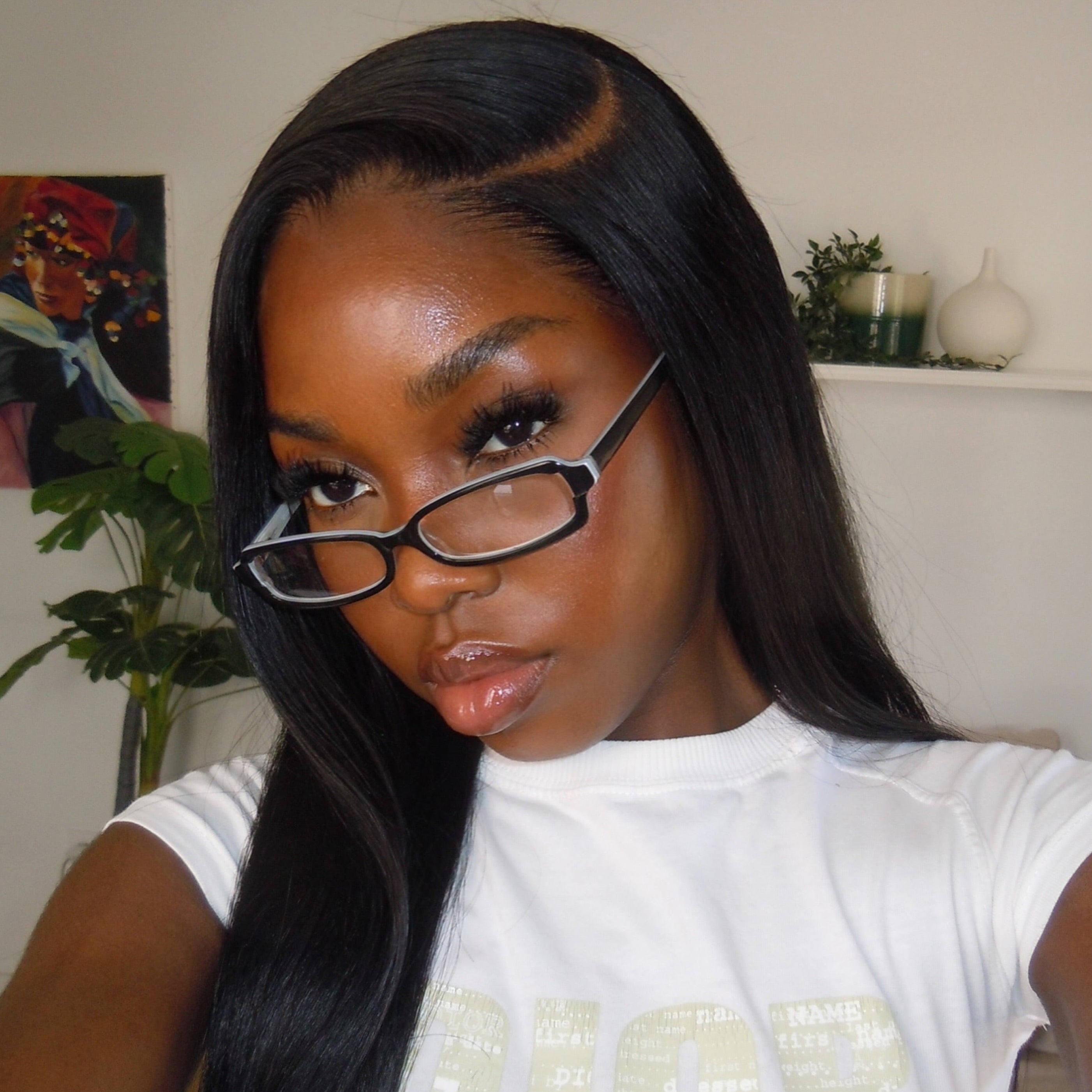 Woman wearing glasses and a white Dior shirt indoors