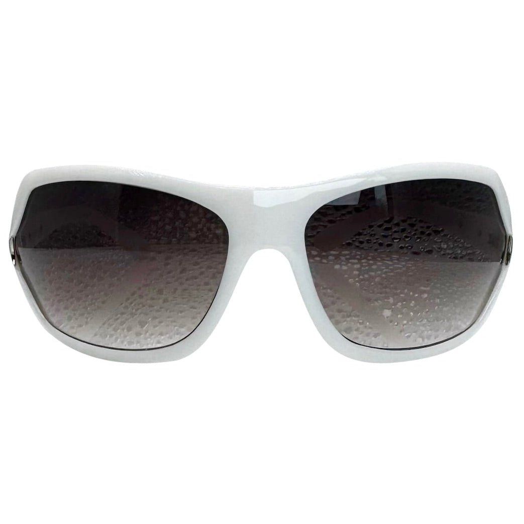 Modern front view of White EXOTIC Shield sunglasses with a bold, polished black frame and dark gradient lenses, showcasing an edgy aesthetic.