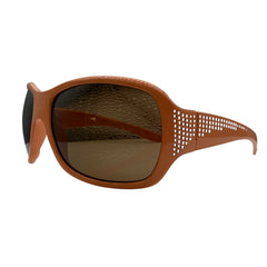 A pair of GLITZ AND GLAM wrap-around sunglasses with a warm brown frame and matching brown-tinted lenses, featuring a perforated pattern on the side arms, shown against a plain white background.