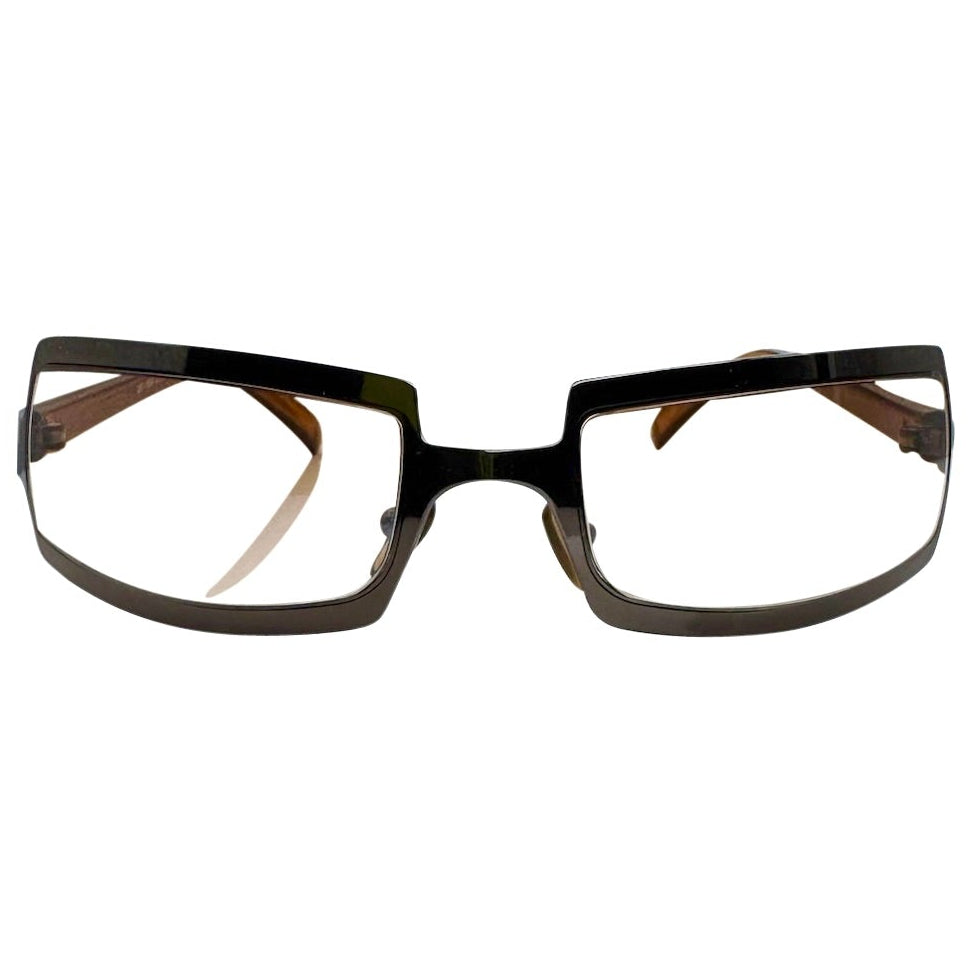 Front view of Brown/Black SHIMMER glasses featuring a high-shine silver metal frame with a unique cutout brow design and clear lenses for a futuristic Y2K look.