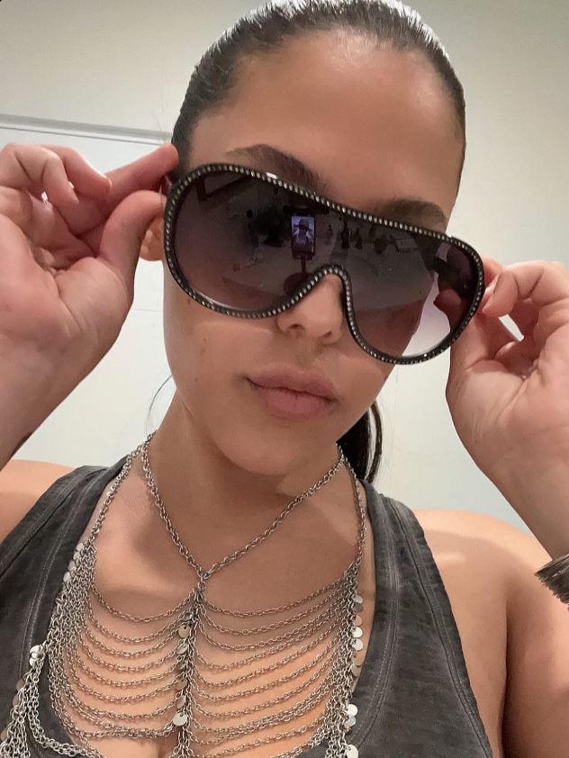 Person wearing large sunglasses with a neutral background