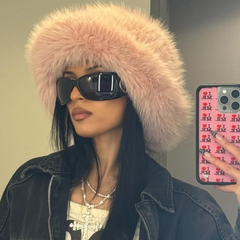Person wearing a fluffy pink hat and sunglasses, holding a phone with a colorful case.