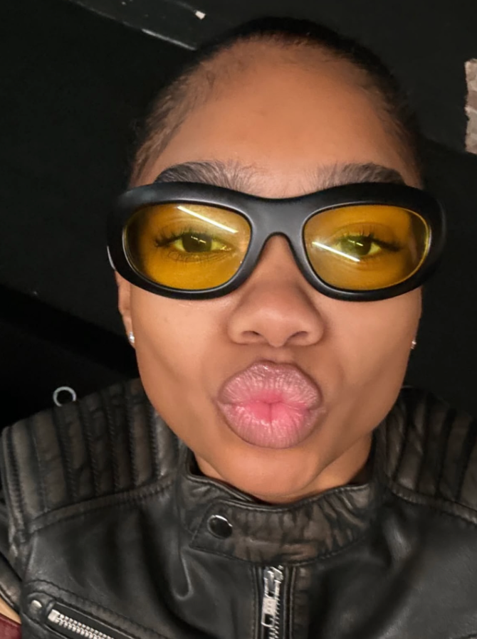 Person wearing reflective sunglasses inside a vehicle