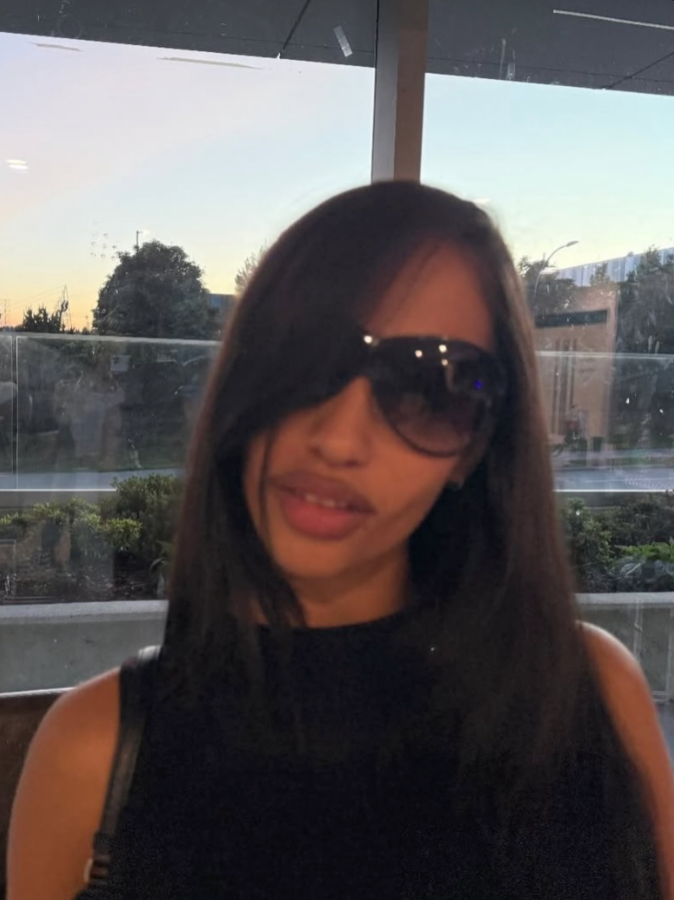 Person wearing sunglasses with a blurred outdoor background