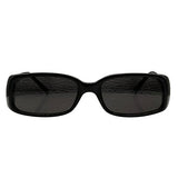 Frontal view of solid black, chunky rectangular sunglasses featuring dark-tinted lenses. The thick acetate frame has a smooth, polished finish with a slightly curved bridge, capturing a bold 90s-inspired minimalist aesthetic.