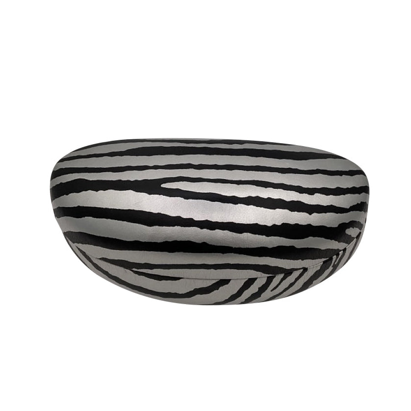 A high-angle view of the closed silver ZEBRA case, displaying the full grey and black zebra stripe pattern across the smooth, rounded top surface.