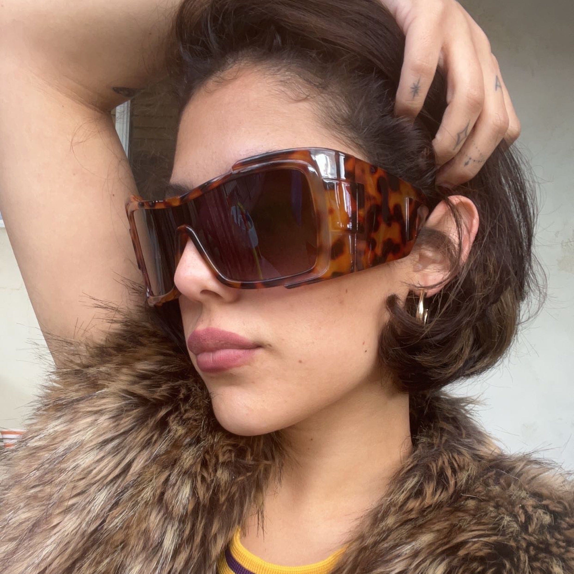 styled photo of shield sunglasses with a smoke lens and oversized tortoise frame 