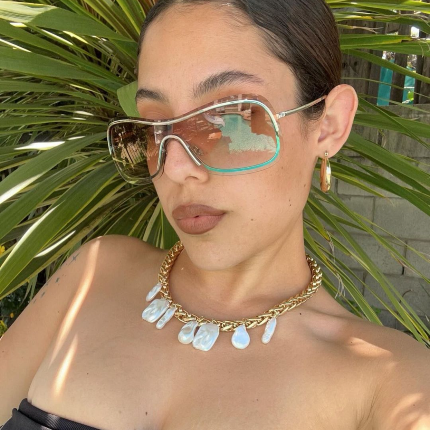 model wearing a giant vintage original sunglass style called REDS amber